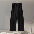 Women's black fleece tracksuit set featuring a pleated long sleeve top and wide leg trousers
