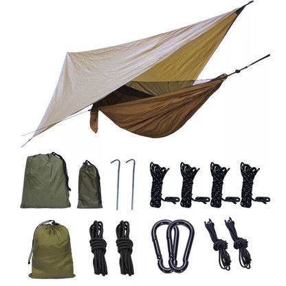 Portable camping hammock with mosquito net and awning setup in a forest