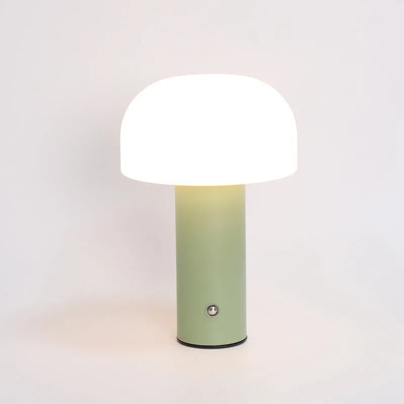 Compact white USB table lamp with integrated UK plug and a charging cable on a wooden desk.