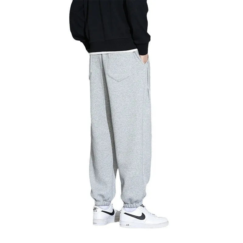 Men's loose gray casual sports trousers with drawstring waist on a hanger