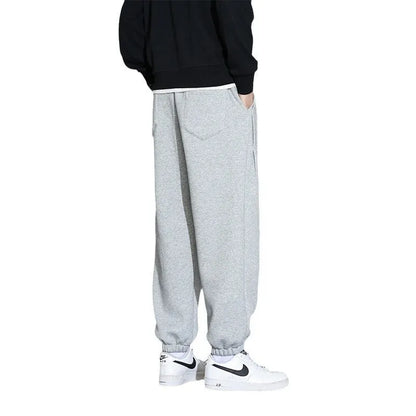 Men's loose gray casual sports trousers with drawstring waist on a hanger