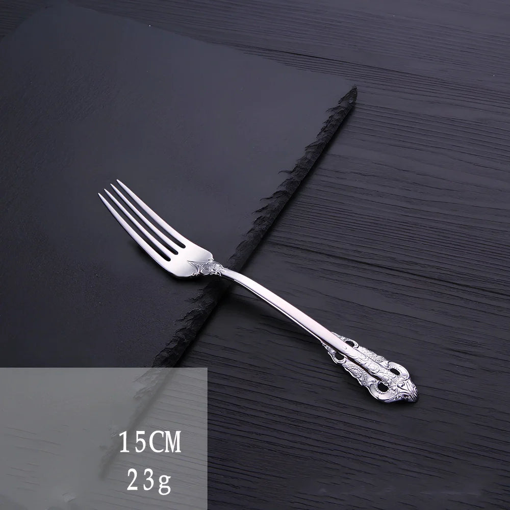 Four-piece stainless steel cutlery set showing main knife, fork, spoon, and teaspoon with mirror finish