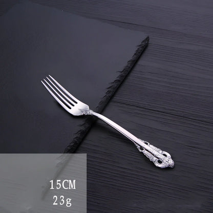 Four-piece stainless steel cutlery set showing main knife, fork, spoon, and teaspoon with mirror finish