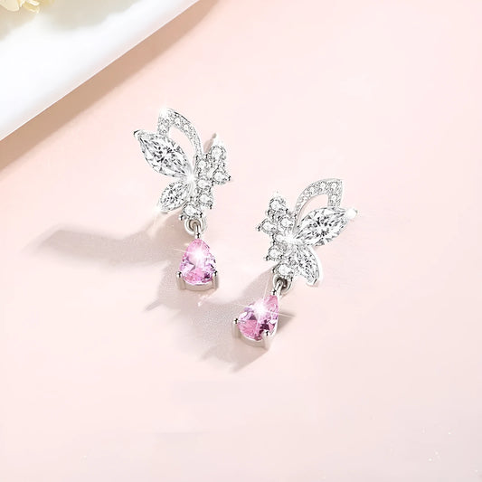 Butterfly shaped silver stud earrings with crystal details on white background