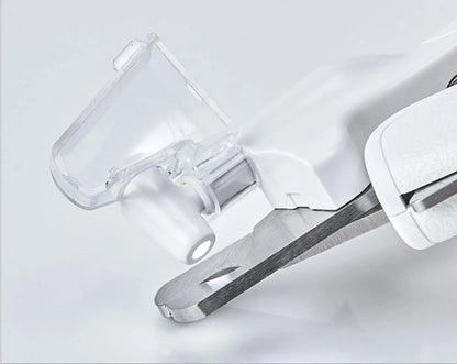 White pet nail clippers with LED light, anti-splash guard, and built-in nail file on a flat surface.