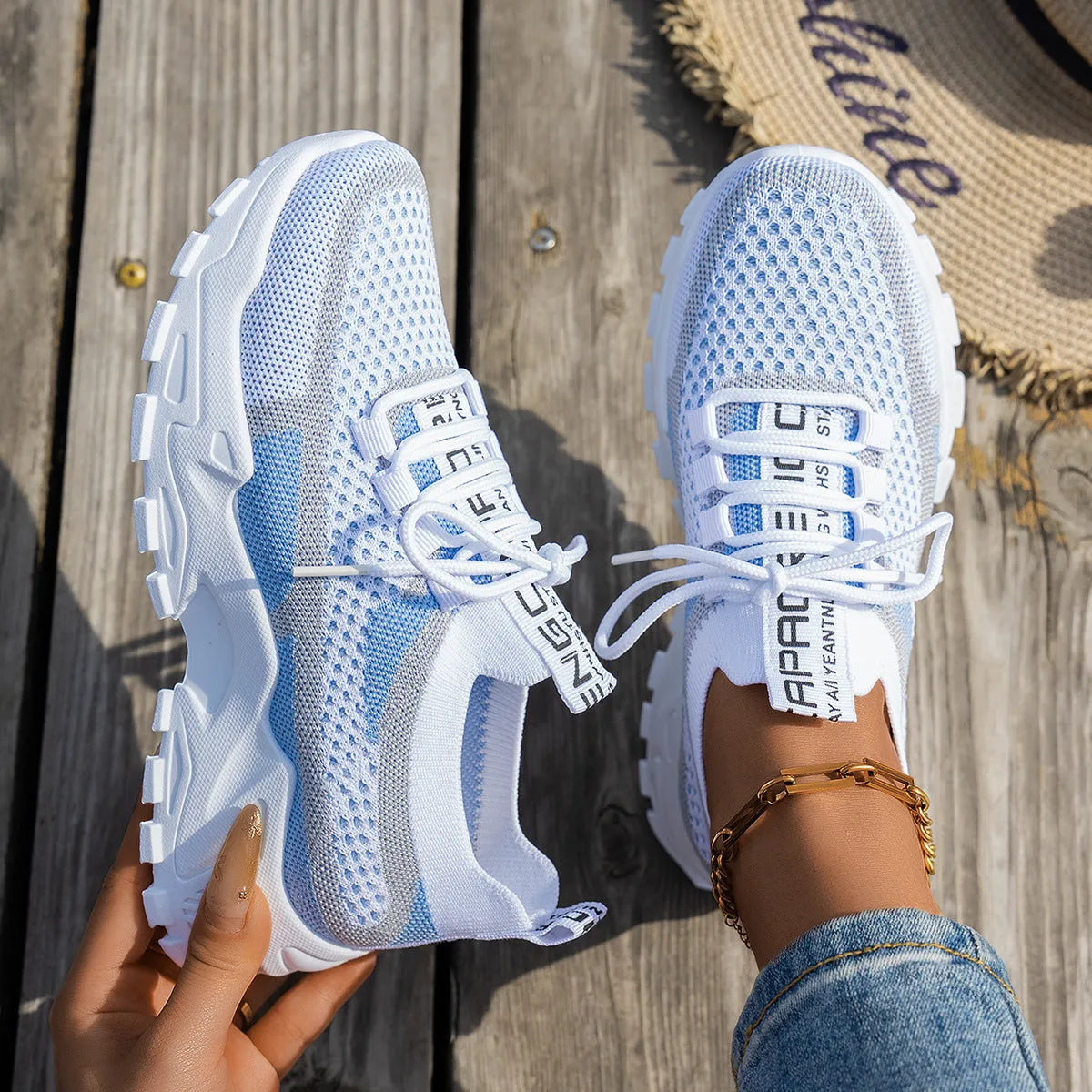 Women's Flyknit mesh lace-up sneakers in a grey colourway on a white background