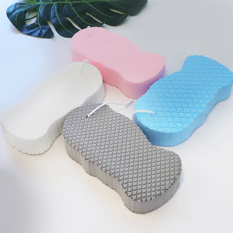 White 3D bath ball sponge with a fish scale exfoliating texture on a blue background.