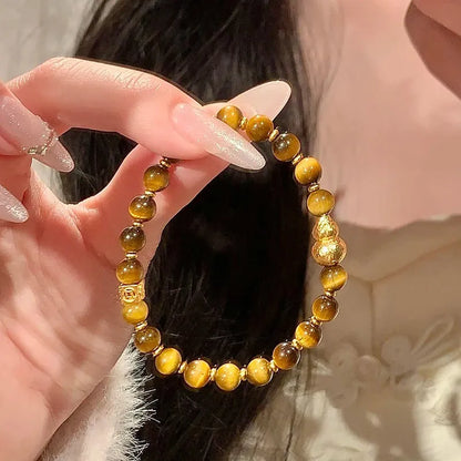 Natural yellow Tiger's Eye bracelet with Hetian jade elements and gold gourd charm on wrist