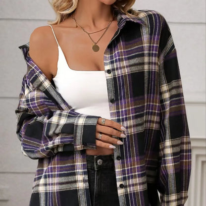 A woman modelling a loose-fit black, green, and purple plaid shirt with long sleeves.