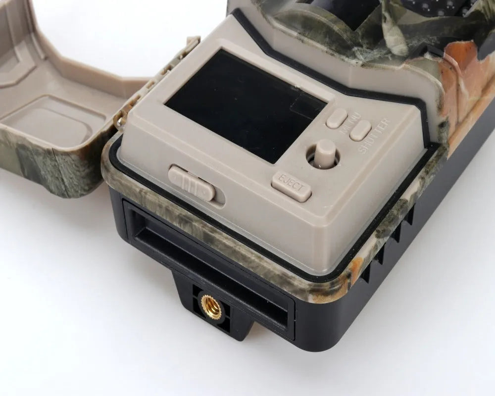 Camouflage infrared hunting trail camera with lens and infrared LEDs, shown with mobile phone displaying APP control interface.