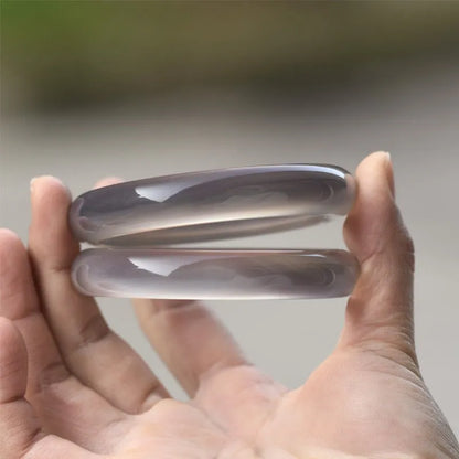 A women's bracelet made from dark grey Brazilian iced chalcedony agate, showing circle and line design elements.