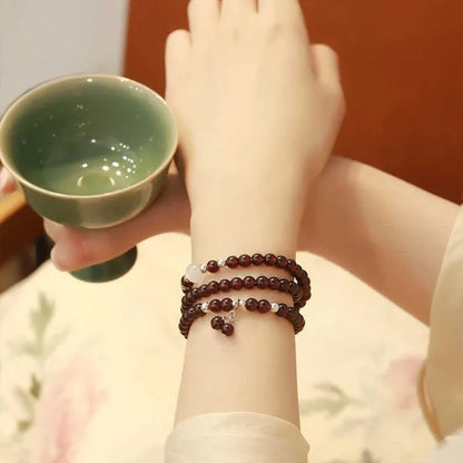 Handmade antique Chinese style bracelet with red imitation garnet and pomegranate design in a gift box.