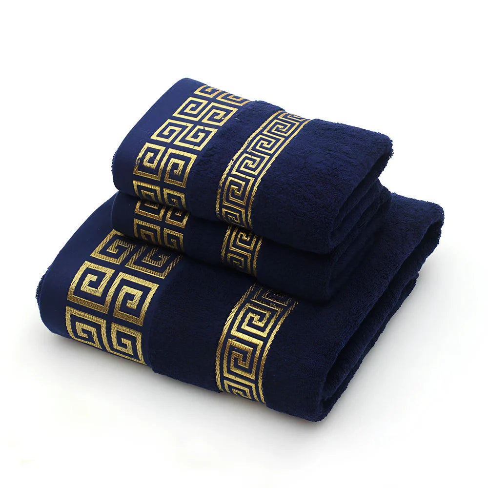 Three-piece cotton towel set showing 70cm bath towel and two 34cm hand towels in white, dark blue, and brown colours