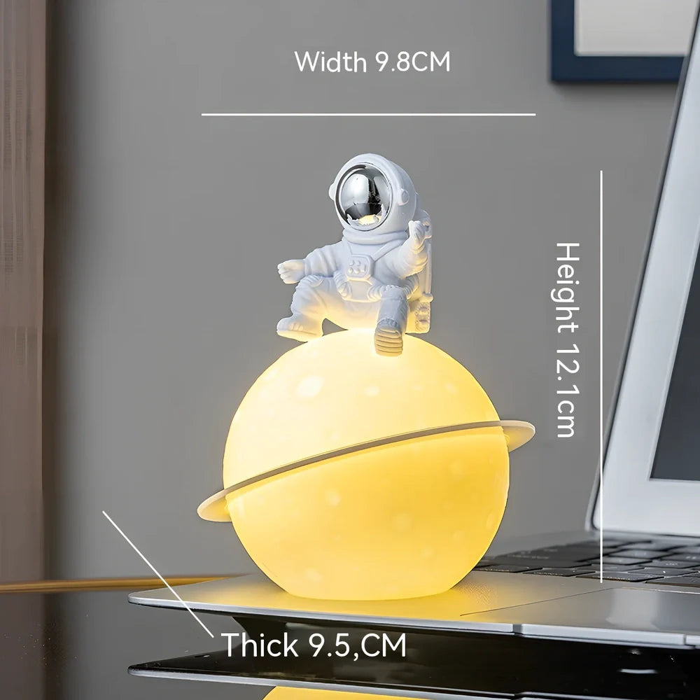 Astronaut planet night lamp in golden finish, 12 cm tall PVC ABS figure with glowing 3 cm orb on 5 cm base