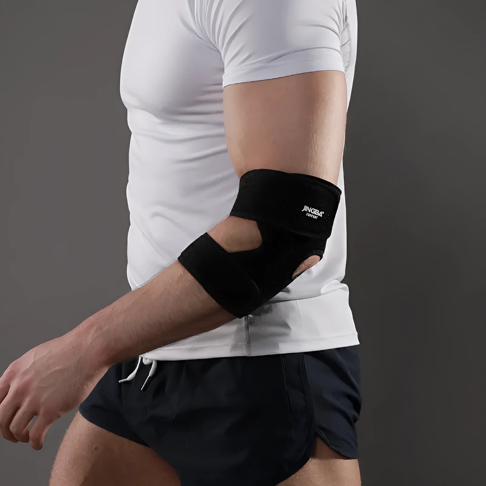 Black adjustable sports elbow guard worn on an adult arm.