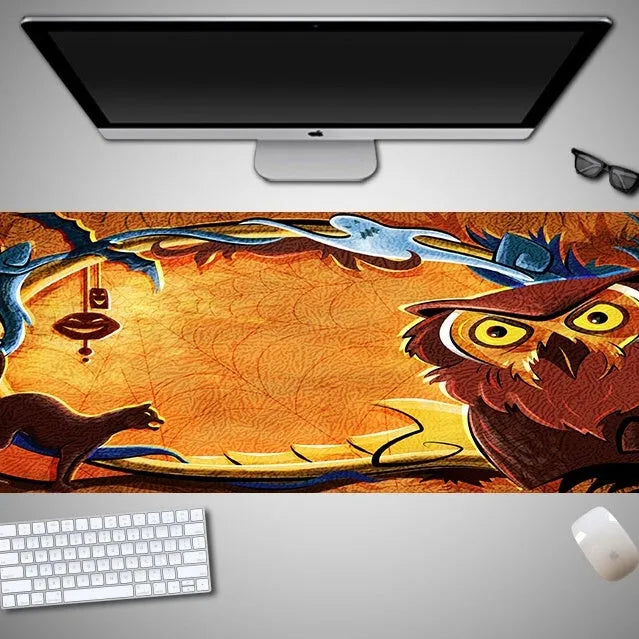 Oversized black Halloween-themed mouse pad with pumpkin design on a wooden desk, showing full 300mm width.