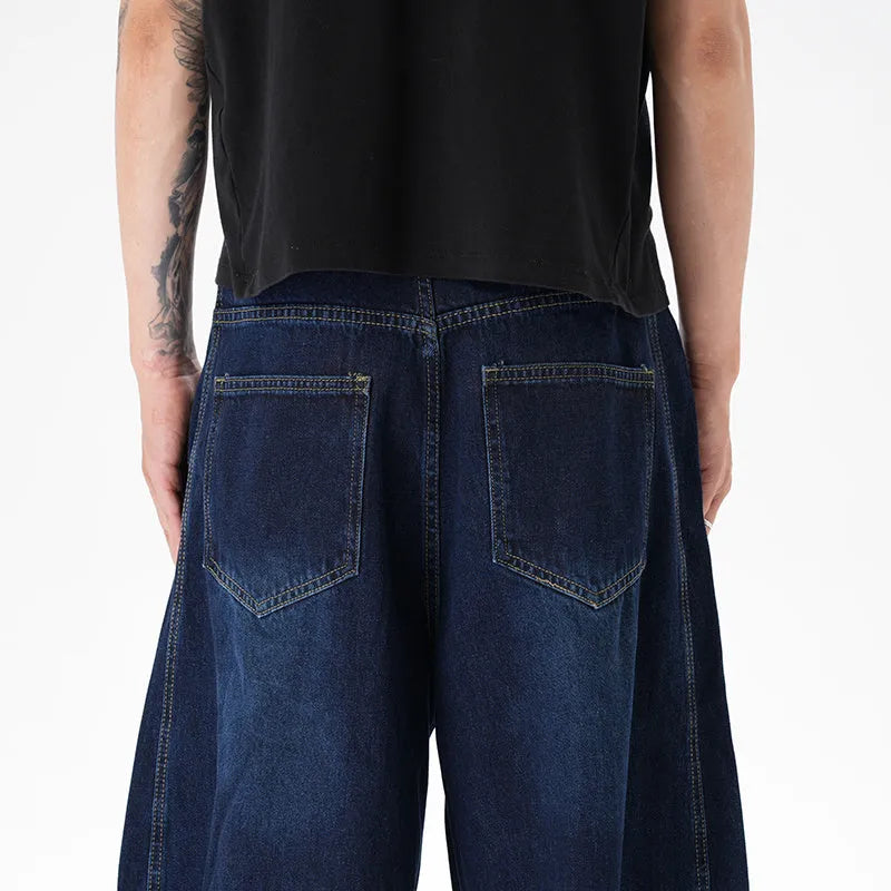 Woman wearing dark blue distressed wide leg denim jeans in a casual setting.