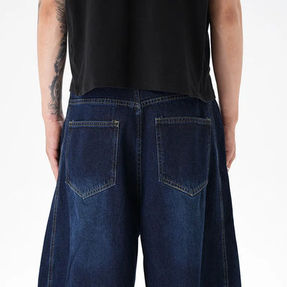 Woman wearing dark blue distressed wide leg denim jeans in a casual setting.