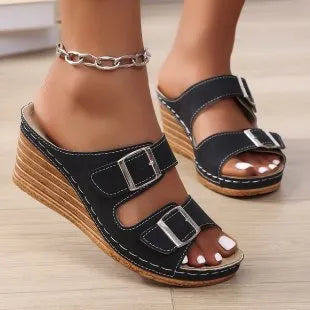 Women's creamy-white wedge slippers with an outer belt buckle and a rubber sole.