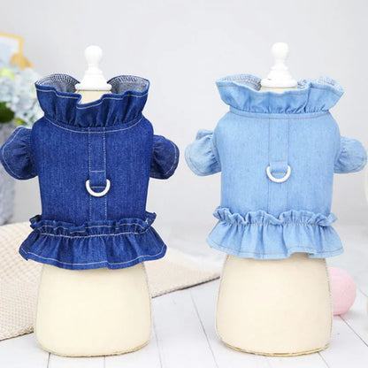 Blue denim dog dress with ruffles and integrated harness for leash attachment.