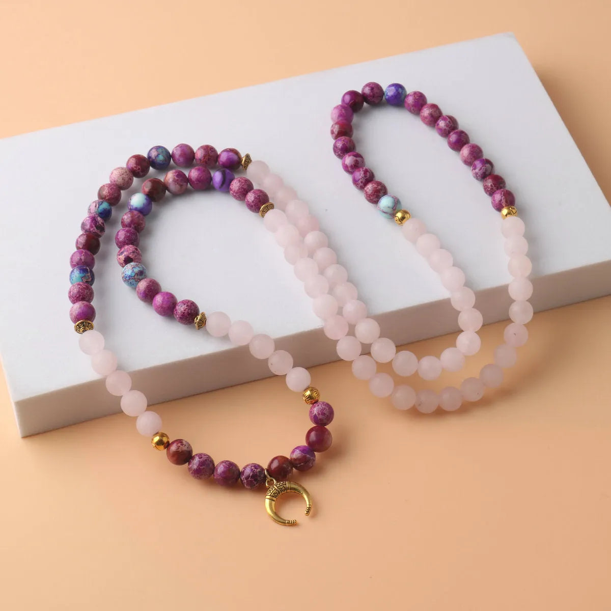 Round pink crystal emperor stone bead pendant on a women's personalised necklace.