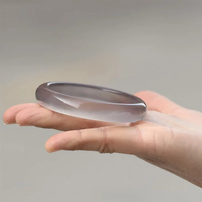 A women's bracelet made from dark grey Brazilian iced chalcedony agate, showing circle and line design elements.