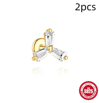 A pair of small golden-toned sterling silver stud earrings with inlaid zircon stones, featuring a delicate chain and clover design.
