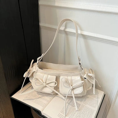 Women's tassel bow shoulder bag in pleated design with multiple pockets, shown in a selected colour.