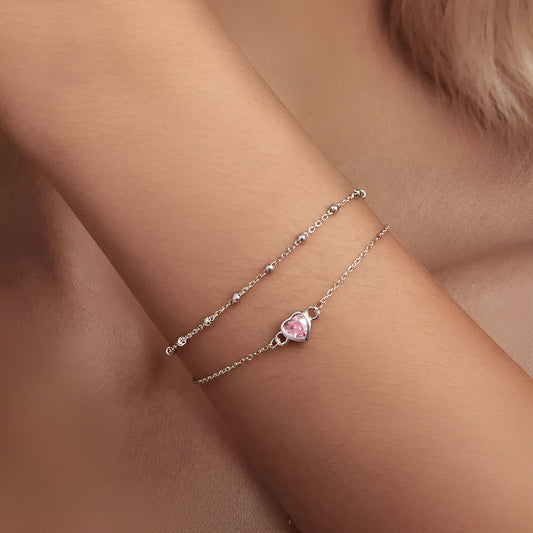 Close-up of a sweet girlish style 925 sterling silver bracelet with a small heart-shaped pendant on an adjustable chain.