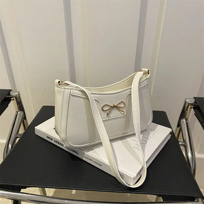 Western style shoulder bag with bow detail in rose pink colour, showing horizontal square shape and single strap.