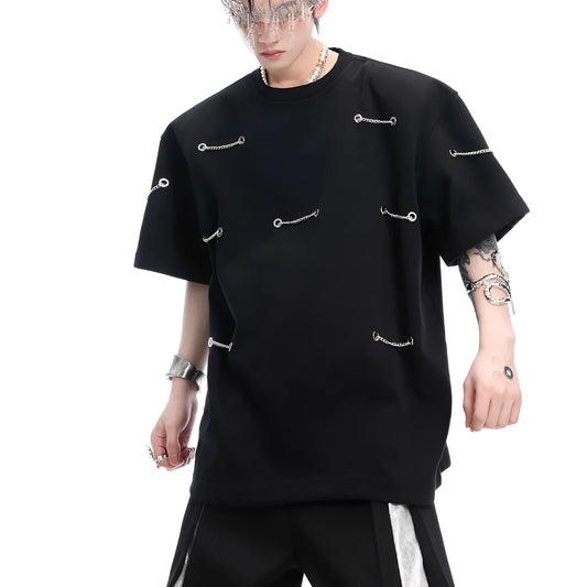 Black padded shoulder T-shirt with metal chain detail on model, showing short sleeves and round neck.