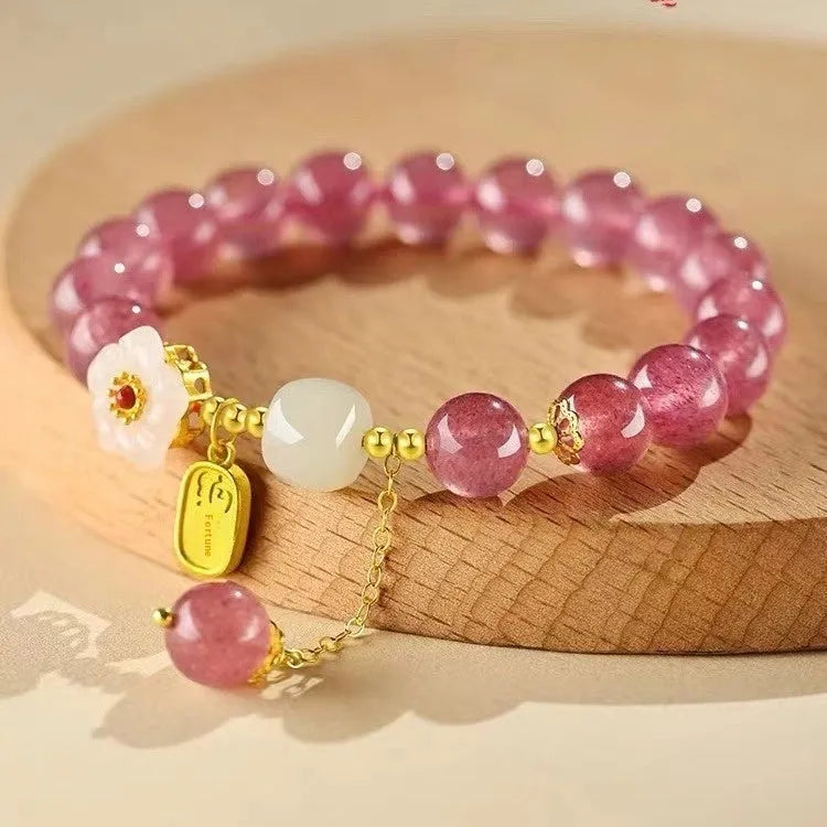 Handcrafted strawberry quartz crystal bracelet with adjustable string closure and Hetian jade peach blossom design