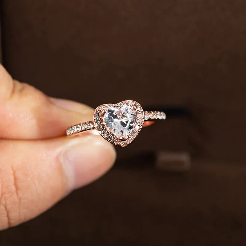 Women's heart-shaped crystal wedding ring in rose gold or silvery on a white background.