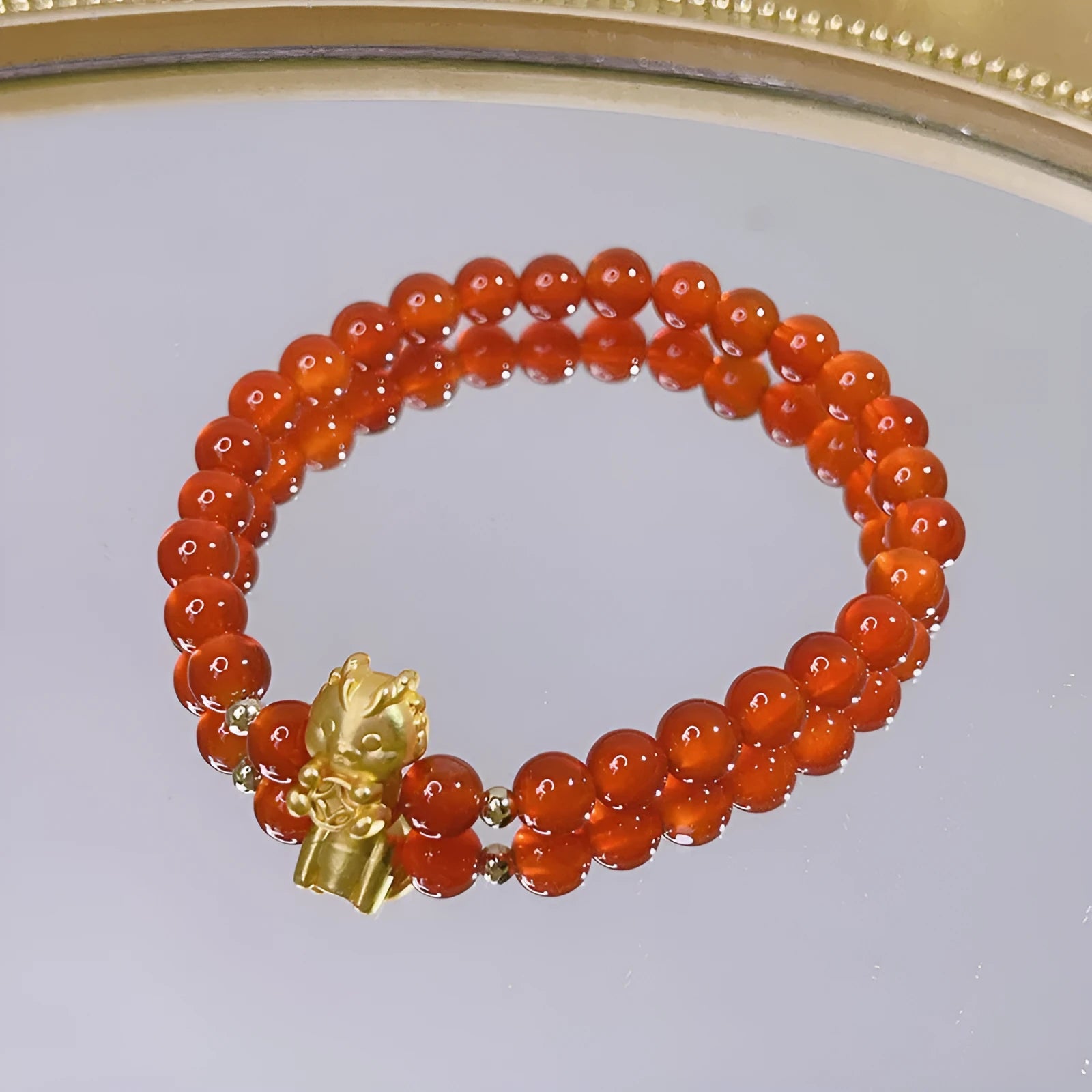 Close-up of a red agate bracelet featuring a detailed dragon design in a Chinese style.
