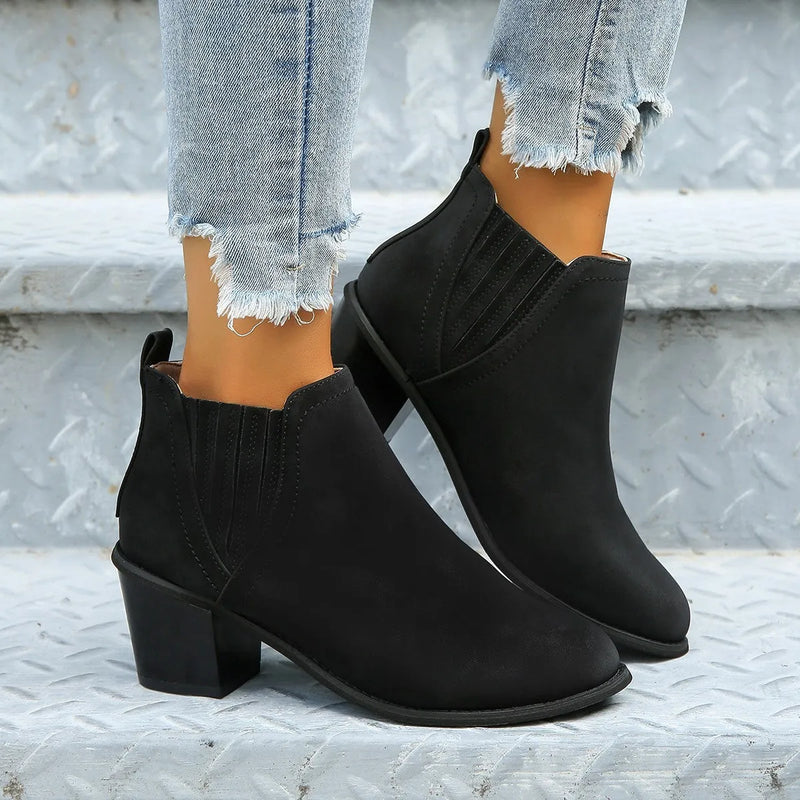 Women's ankle boots with a pointed toe, thick square heel, and slip-on low heel design, available in black and brown colours, made from artificial PU upper material and a rubber sole, suitable for autumn and winter wear