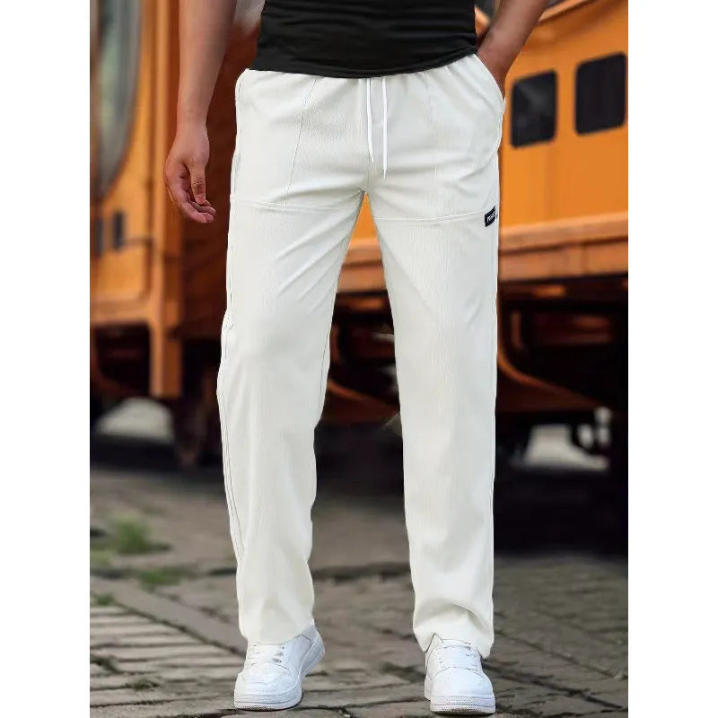 Men's polyester trousers for spring and autumn in light grey, shown in a casual setting