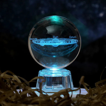 Transparent crystal ball ornament with inner carving of clouds, shown on a wooden table.