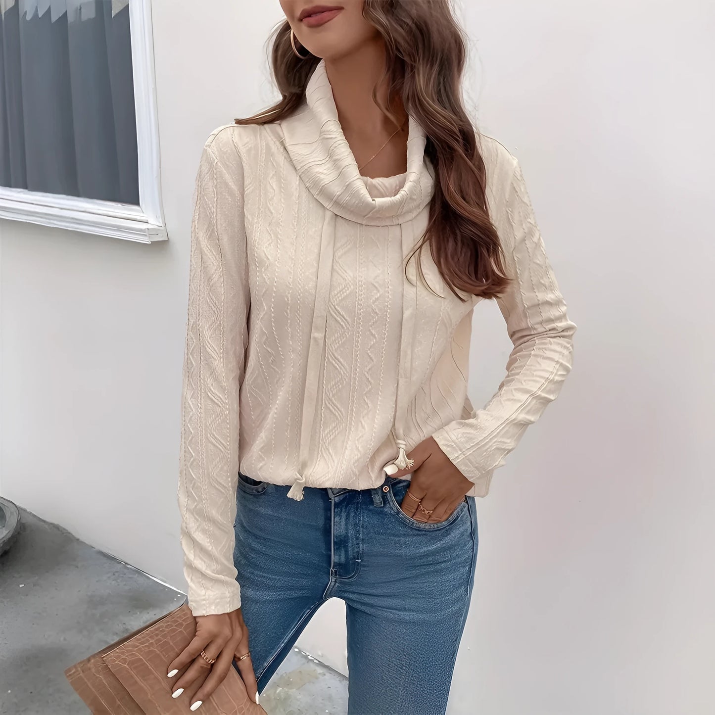 Apricot coloured long sleeve hooded pullover sweater with drawstring on a hanger