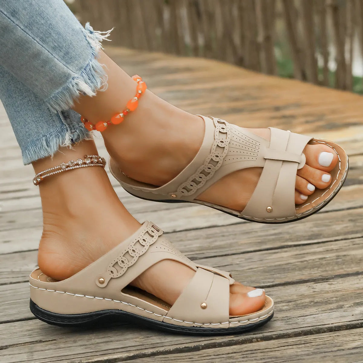Blue roman style slippers with a slope heel and fish mouth toe holder on a wooden floor.