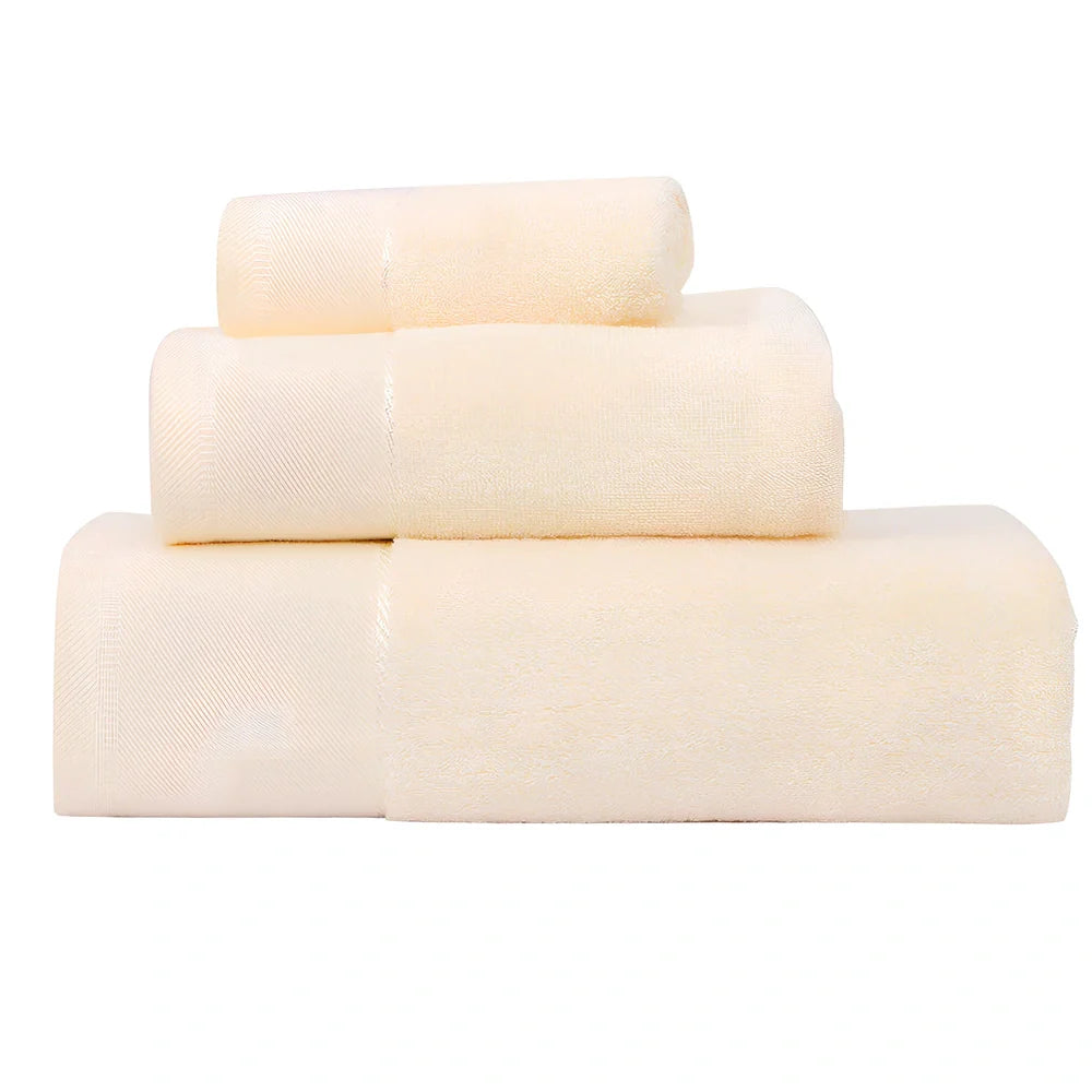 Three-piece cotton towel set showing 70x140cm bath towel, 35x75cm face towel, and 32x32cm square towel with combed yarn texture