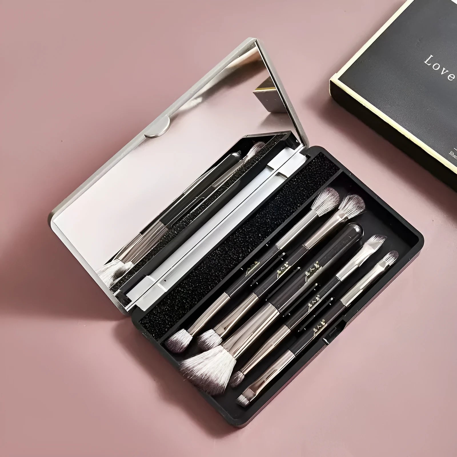 Makeup brush set with mirror compact case showing silver or gold brushes with artificial fibre bristles