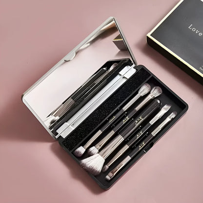 Makeup brush set with mirror compact case showing silver or gold brushes with artificial fibre bristles