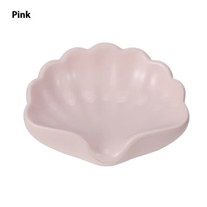 Plastic shell soap dish in pearl white, dimensions 12x9x5.5cm, on a bathroom counter