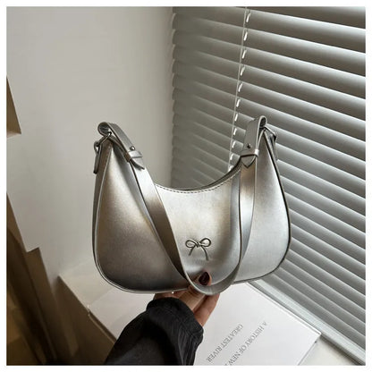 Women's silver dumpling-shaped PU crossbody bag showing front sandwich pocket and single shoulder strap.