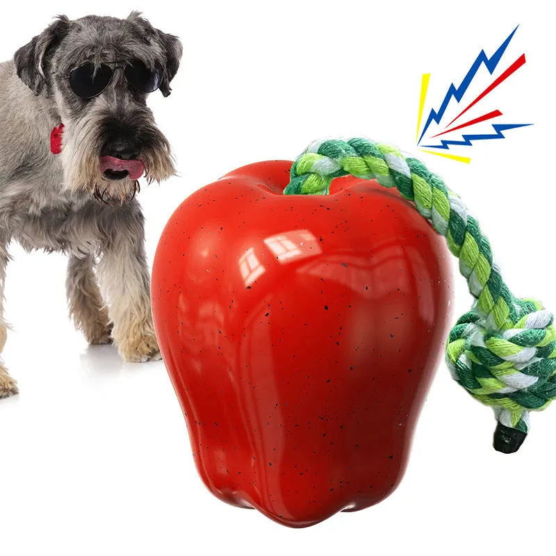 Green and red apple-shaped plastic dog toy with textured surface and a treat hole for interactive chewing.