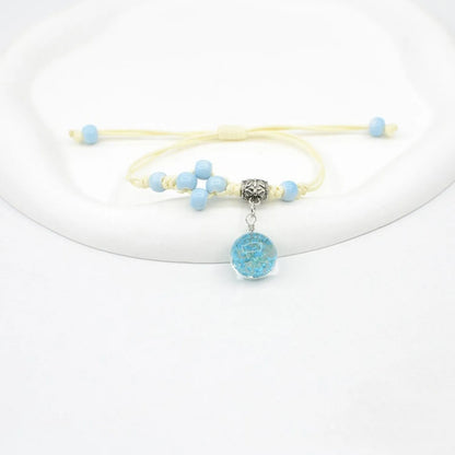 Hand-woven glass bracelet with large 1.4 cm beads containing real dried flowers, shown in blue.