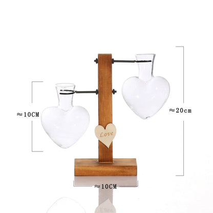 Elegant heart-shaped glass terrarium with wooden stand, showcasing a natural, minimalist design perfect for indoor plant display or decorative accents.