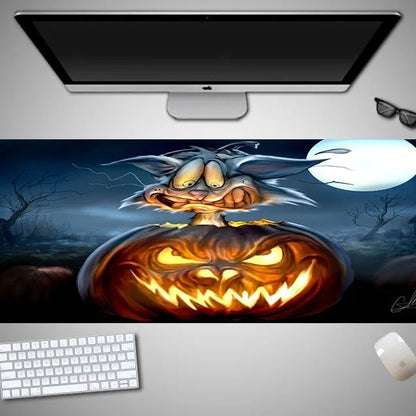 Oversized black mouse pad with Halloween-themed graphic, shown on a wooden desk with keyboard and gaming mouse.