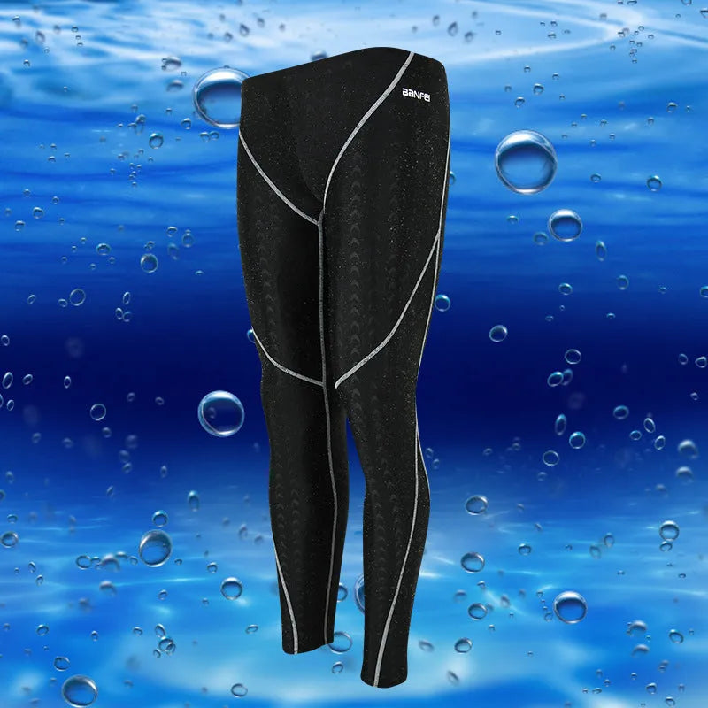 Men's black and grey cropped nylon swimming trunks with mesh lining, laid flat.