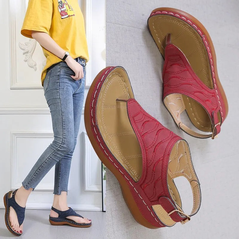 Women's wedge heel flip flop sandals in black with adjustable back strap on a light background